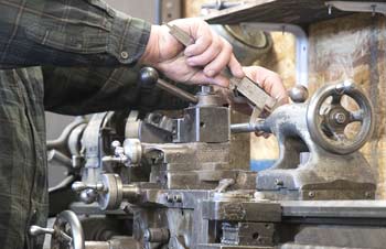 Water pump shaft being turned on lathe